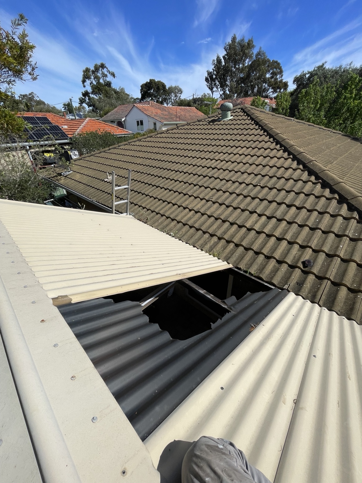 Broken patio roof sheet with a large opening before replacement